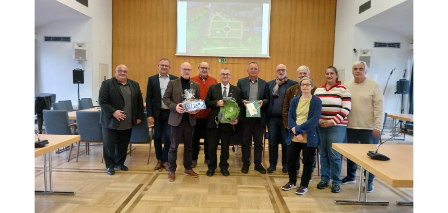 Mehrere Personen stehen zu einem Foto im Sitzungssaal zusammen. 