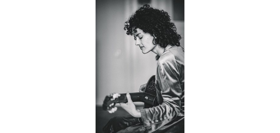 Bild von einer Frau mit einer Gitarre in schwarz-weiß