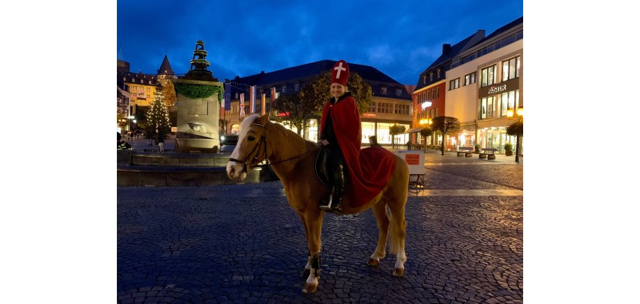 Frau auf einem Pferd in einem St. Martins Kostüm