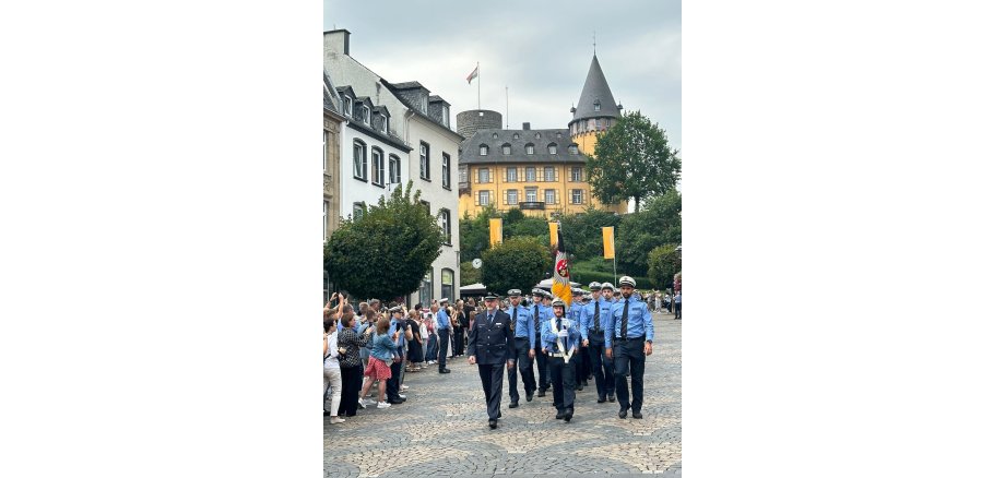 Mehrere Personen marschieren in Uniform auf den Marktplatz