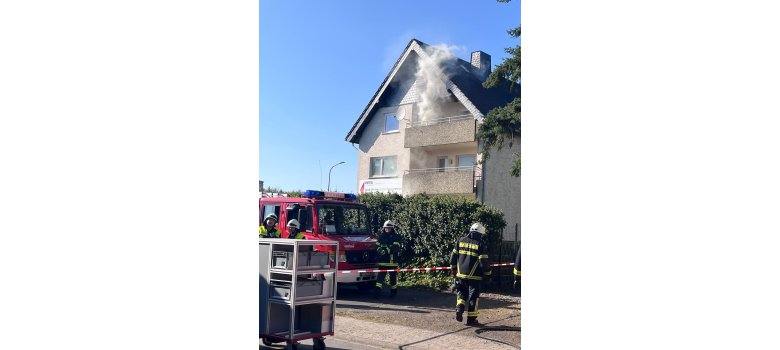 Feuerwehrleute bewältigen einen simulierten Wohnhausbrand mit Rauchentwicklung zur realistischen Vorbereitung