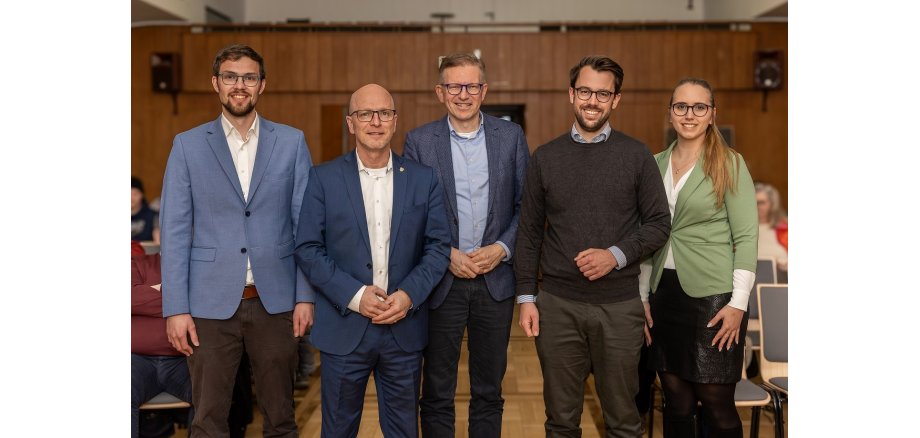 5 Personen stehen für ein Gruppenfoto zusammen