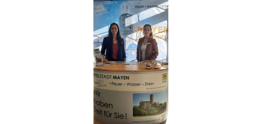 Zwei Personen hinter einem Messestand